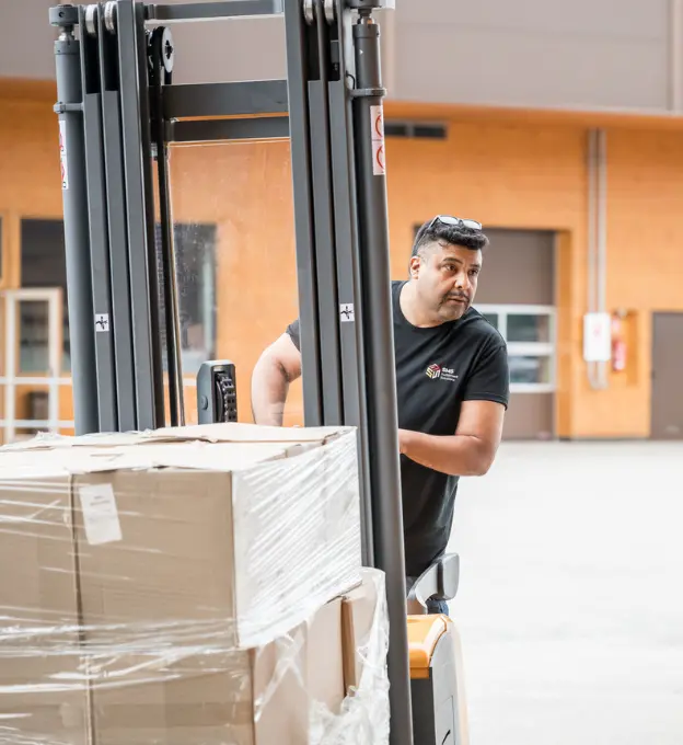 Warehouse worker at SMS Fulfillment solutions handling a fork lifter